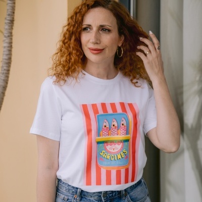 Camiseta branca com estampa colorida de lata de sardinhas e calças de ganga azuis