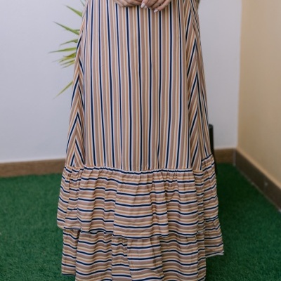 Saia comprida com riscas bege, azul e branco e folhos, usada com botins castanhos