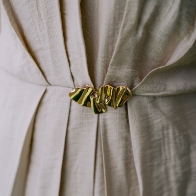 Vestido bege claro com cinto dourado ondulado