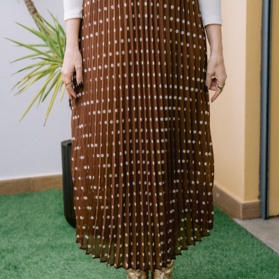 Saia midi plissada castanha com bolinhas brancas e botas douradas