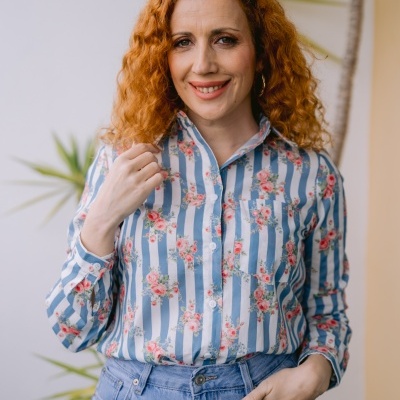 Mulher com camisa de riscas azuis e flores e calças de ganga com remendos