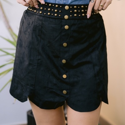 Saia preta curta com botões dourados e cinto com tachas douradas
