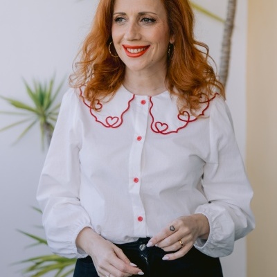 Blusa branca com botões vermelhos e bordado em forma de corações vermelhos na gola