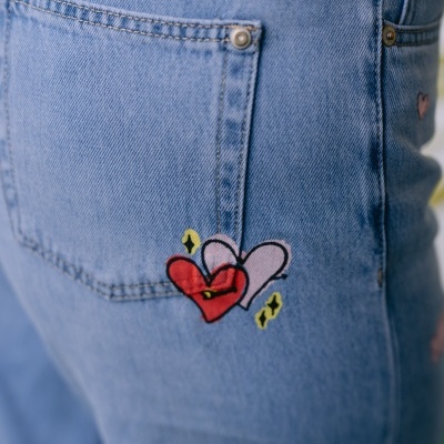 Calças de ganga azuis com bordado de corações no bolso traseiro