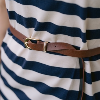 Roupa às riscas azul e creme com cinto de couro castanho