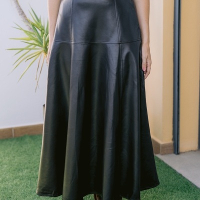 Saia preta midi de tecido que parece pele com costuras e blusa branca.