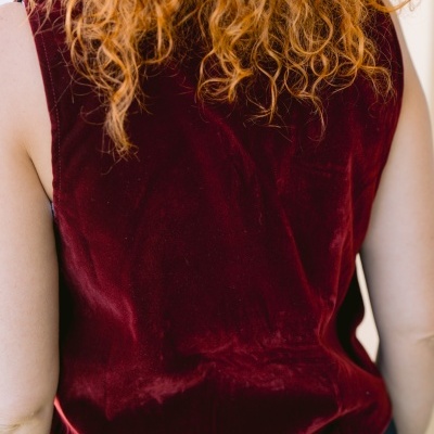 Camisola sem mangas bordeaux de veludo vista de costas com cabelo loiro encaracolado