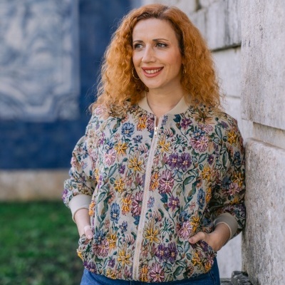 Casaco feminino floral bege e calças de ganga azuis ao ar livre