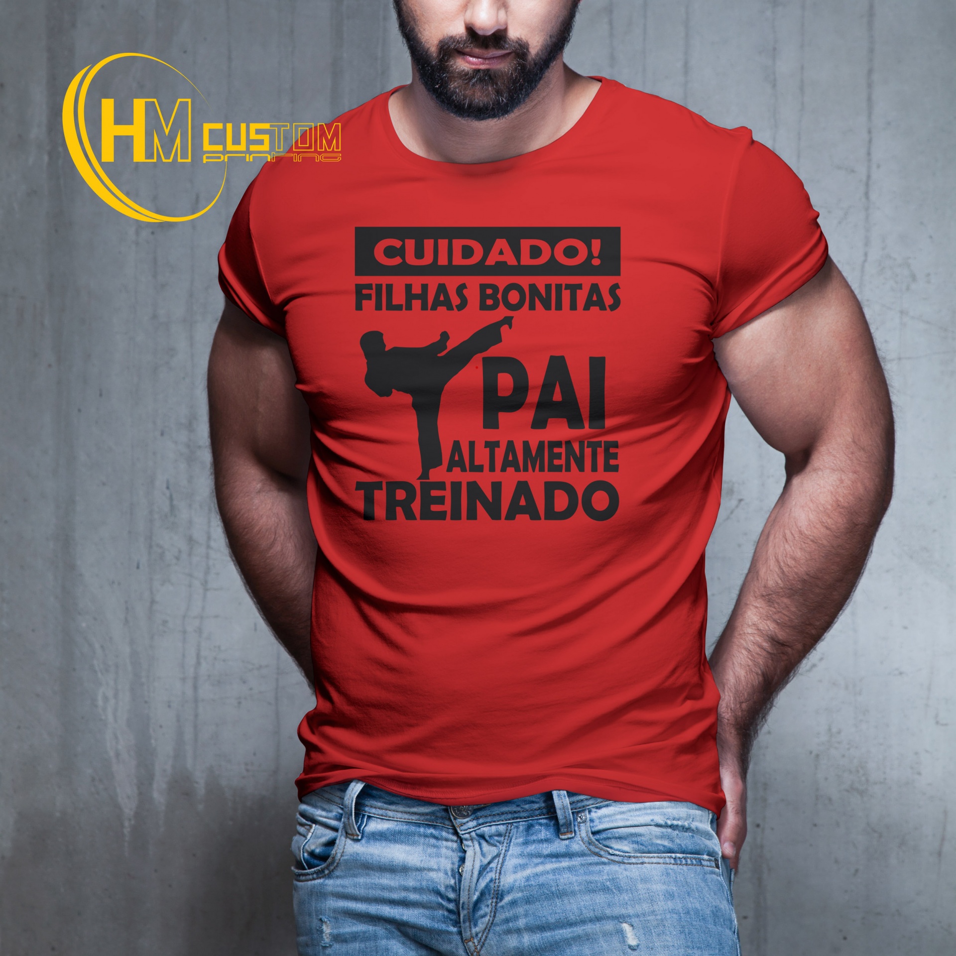 Cuidado Filhas Bonitas Pai Altamente Treinado T-shirt vermelha com texto e figura em preto, usada por homem de barba em fundo cinzento