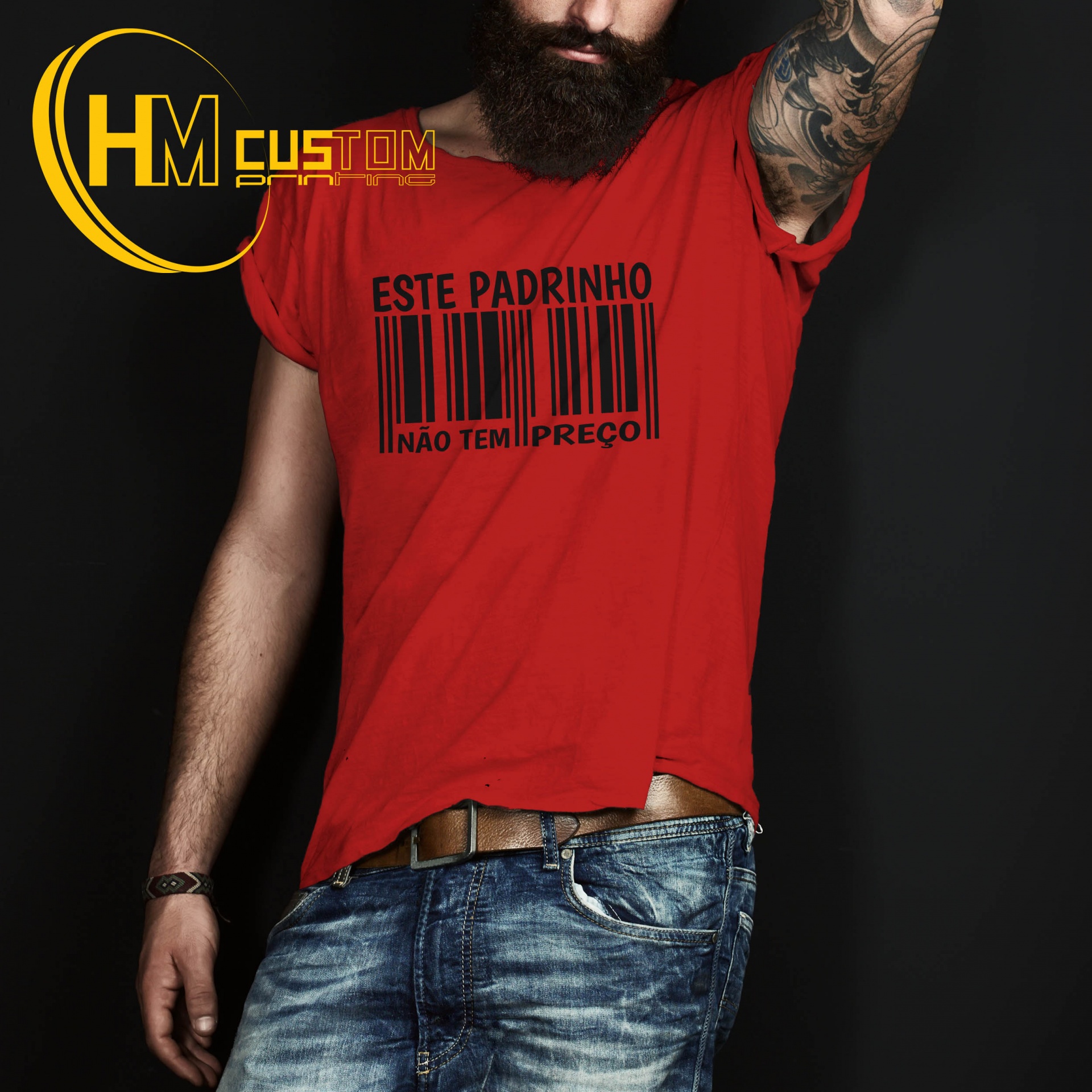 Este Padrinho não tem Preço Camiseta vermelha com estampa preta de código de barras e texto, usada por homem com calças de ganga e tatuagem