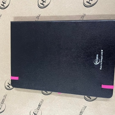 Caderno preto com elásticos rosa e texto branco sobre papel com logotipo HM Express