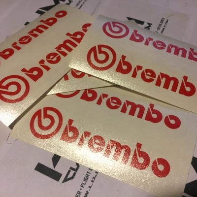 Autocolantes brancos com o logotipo e texto 'brembo' em vermelho