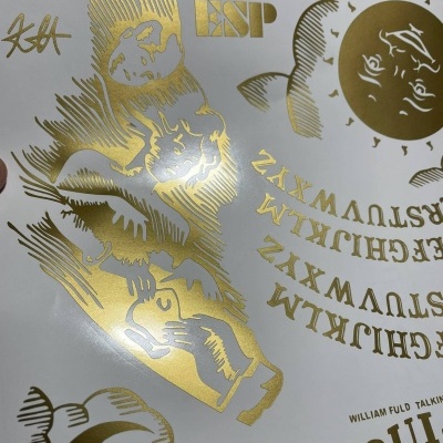 Folha autocolante com desenhos e texto dourado em fundo branco