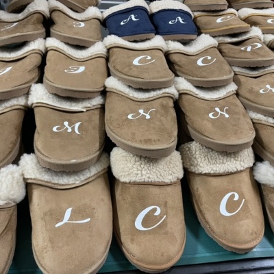 Pantufas castanhas com lã branca e letras bordadas no topo