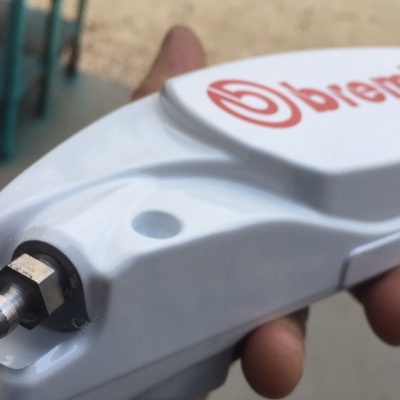 Pinça de travão automóvel branca Brembo em mão