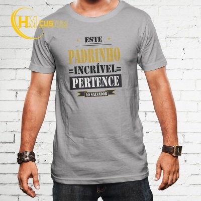 T-shirt cinzenta com texto em várias cores, vestida por homem com pulseiras, fundo de parede branca de tijolos