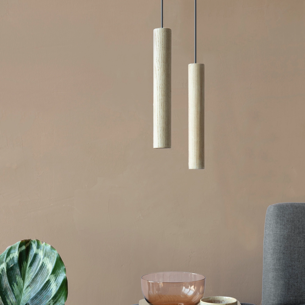 Candeeiro de Teto Chimes em Madeira de Carvalho – 22 cm Lâmpadas pendentes cilindricas de madeira clara junto a planta e tigela numa mesa