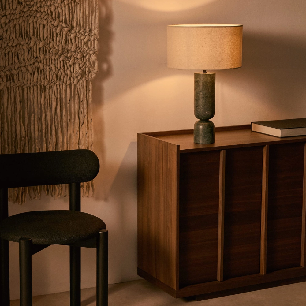 Candeeiro de Mesa em Mármore e Linho Vexis Cadeira preta, cómoda de madeira e lâmpada com abajur em ambiente decorado