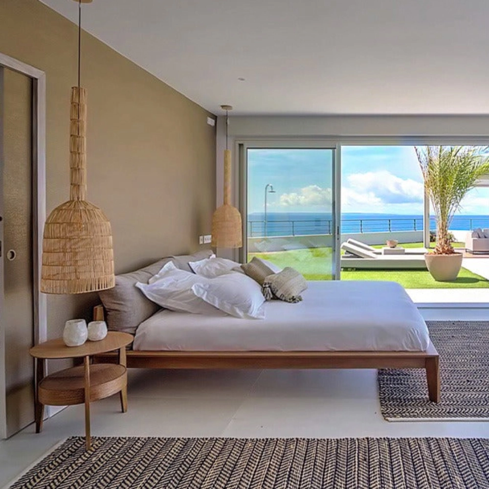 Candeeiro de Teto em Rattan Umut Ø35x114 Quarto minimalista com cama de madeira, abajur de vime e vista para terraço e mar