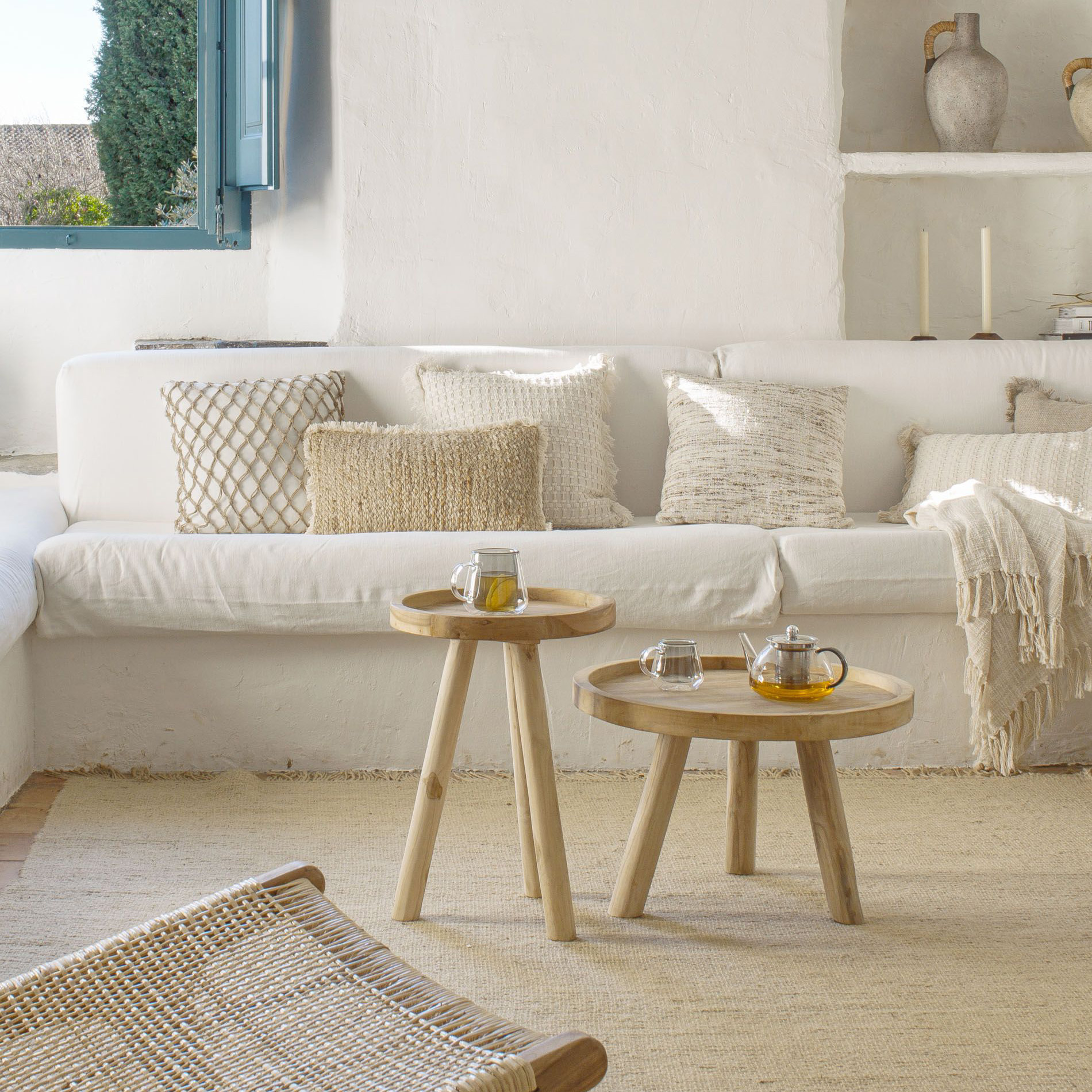 Mesa de centro Genda, madeira teca, Ø55x36 Sala de estar com sofá branco, almofadas, mesas de madeira com chá, tapete bege e janela azul