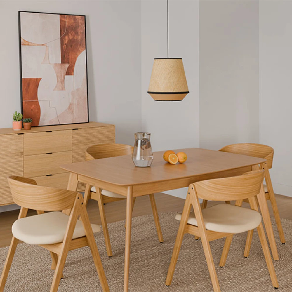 Mesa extensível em carvalho Kenna 140-180 x 90 cm Conjunto de sala de jantar com mesa e cadeiras em madeira clara, jarra de vidro e laranjas na mesa, luz pendente e aparador com pintura abstrata