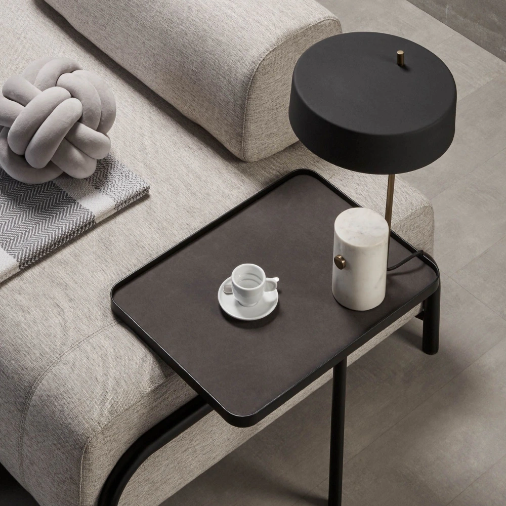 Candeeiro de Mesa em Mármore Phanton Mesa auxiliar preta com abajur e chávena ao lado de sofá cinza