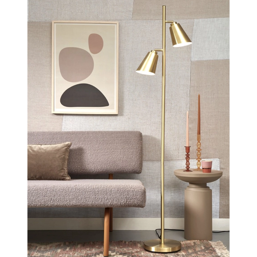 Candeeiro de Pé em Metal com Dois Focos Giratórios Bremen Lâmpada de pé dourada junto a sofá cinza e mesa lateral com castiçais e vela