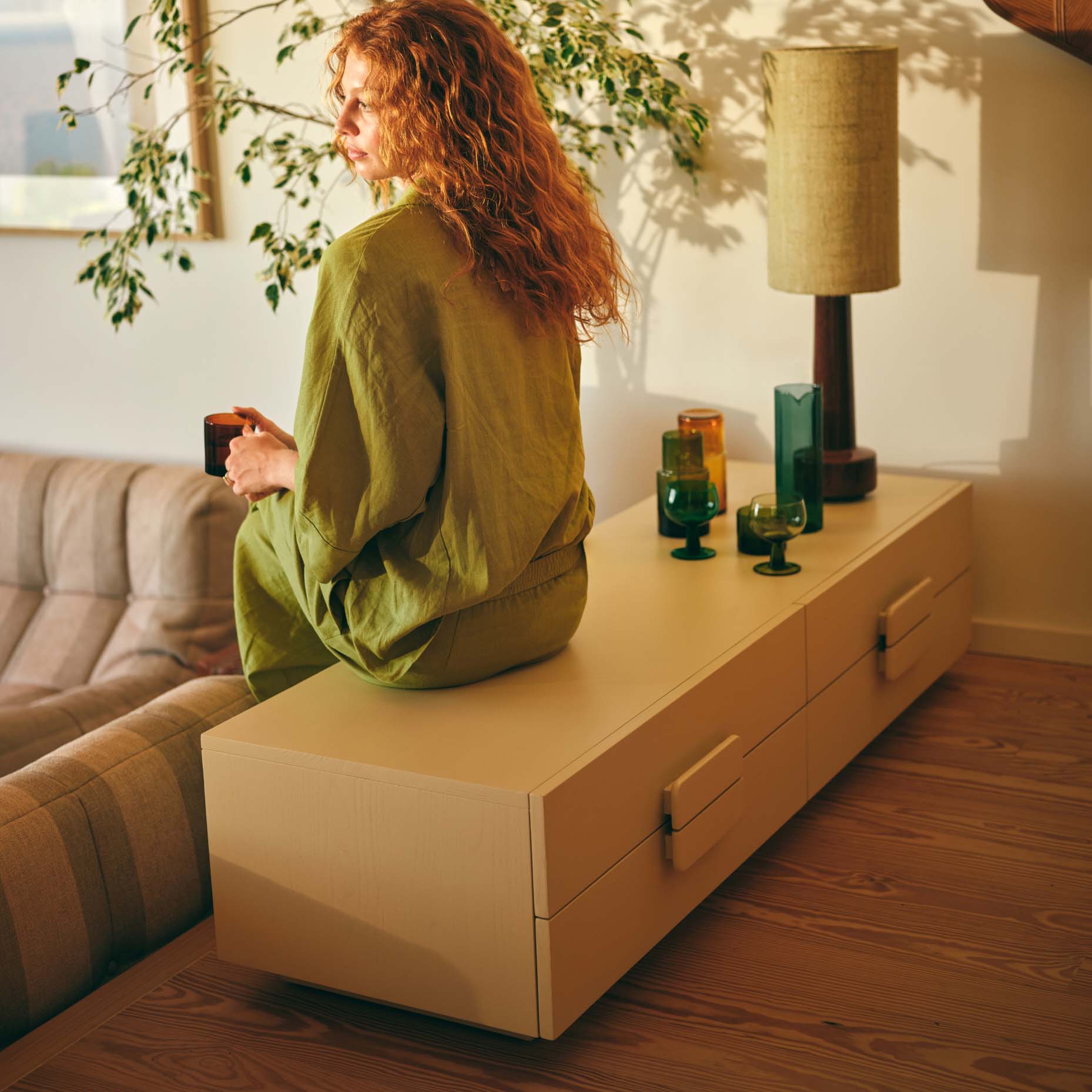 Aparador Nordic, madeira sungkai, bege, 160x54 Cómoda de madeira clara com gavetas e objetos decorativos em vidro verde e âmbar