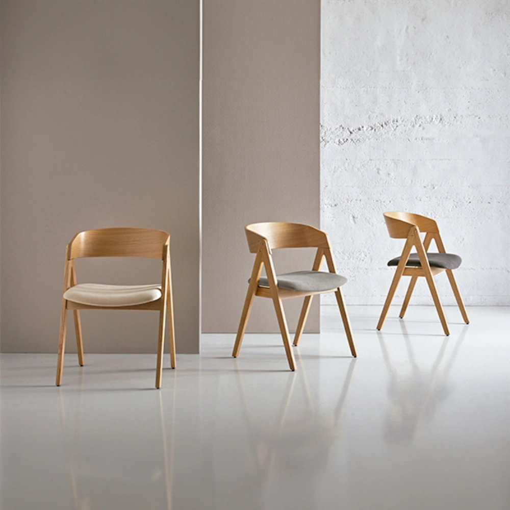 Cadeira estofada com braços em carvalho Rina Três cadeiras de madeira clara com assentos estofados cinzentos e bege num ambiente minimalista