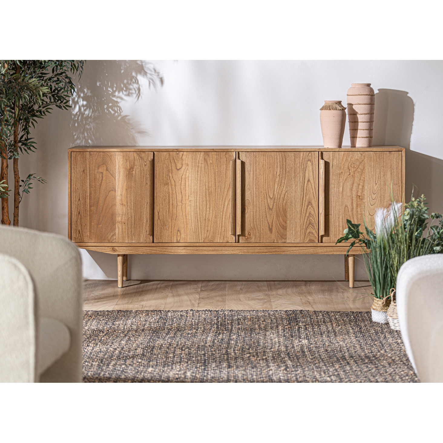 Aparador Niry, madeira mindi, 200x84 Aparador de madeira clara com quatro portas numa sala decorada com vasos e plantas