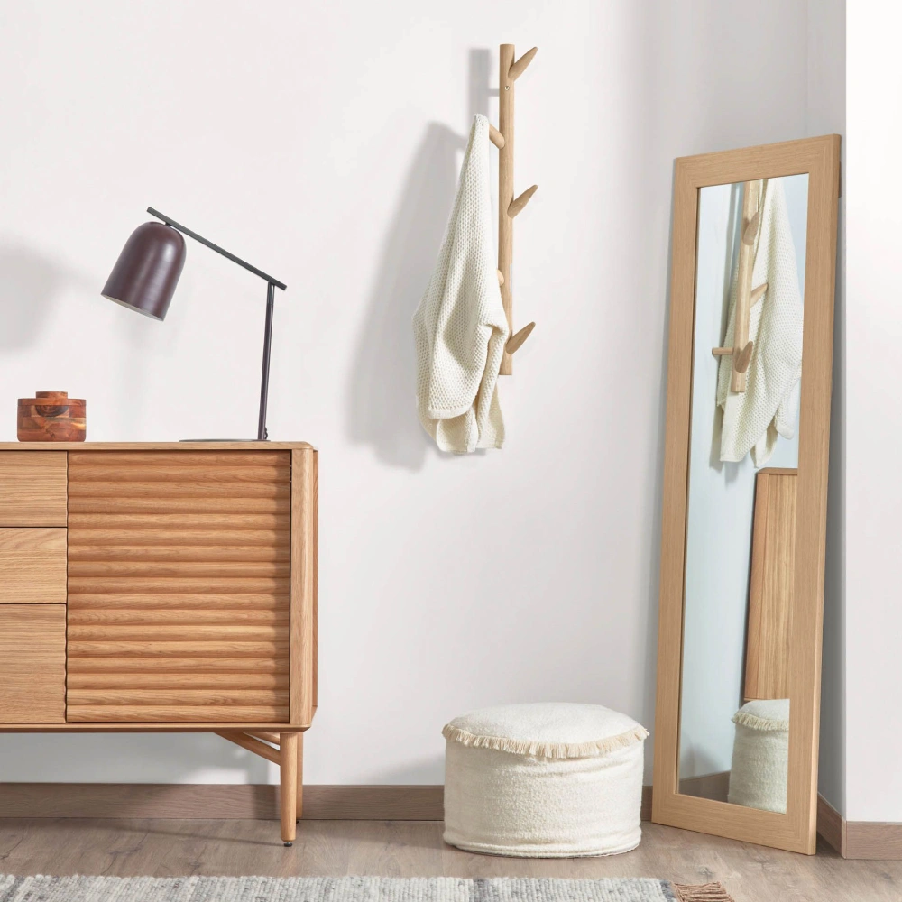 Cabide de parede Nattan, madeira bétula, 75cm Móvel de madeira clara, lâmpada preta, cabide de parede com casaco branco, espelho de corpo inteiro e pufe branco num quarto minimalista