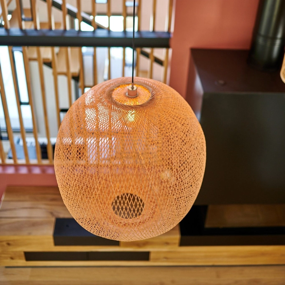 Candeeiro de teto Plum em Bambu Natural Candeeiro suspenso de material trançado cor bege em sala com parede salmão.
