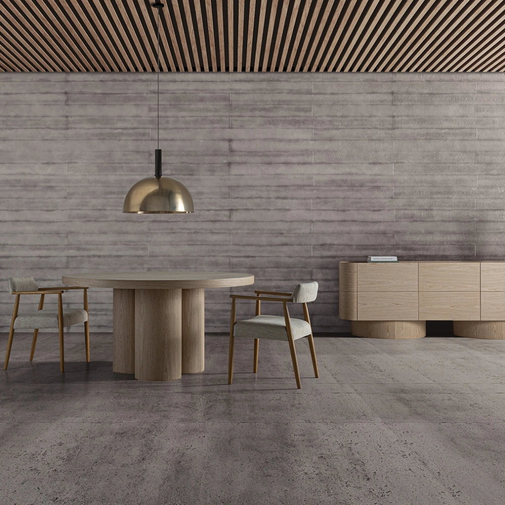 Mesa de jantar em madeira carvalho Prayssac Ø150x76 Sala de jantar minimalista com mesa e cadeiras de madeira clara, candeeiro dourado e parede e chão cinza.