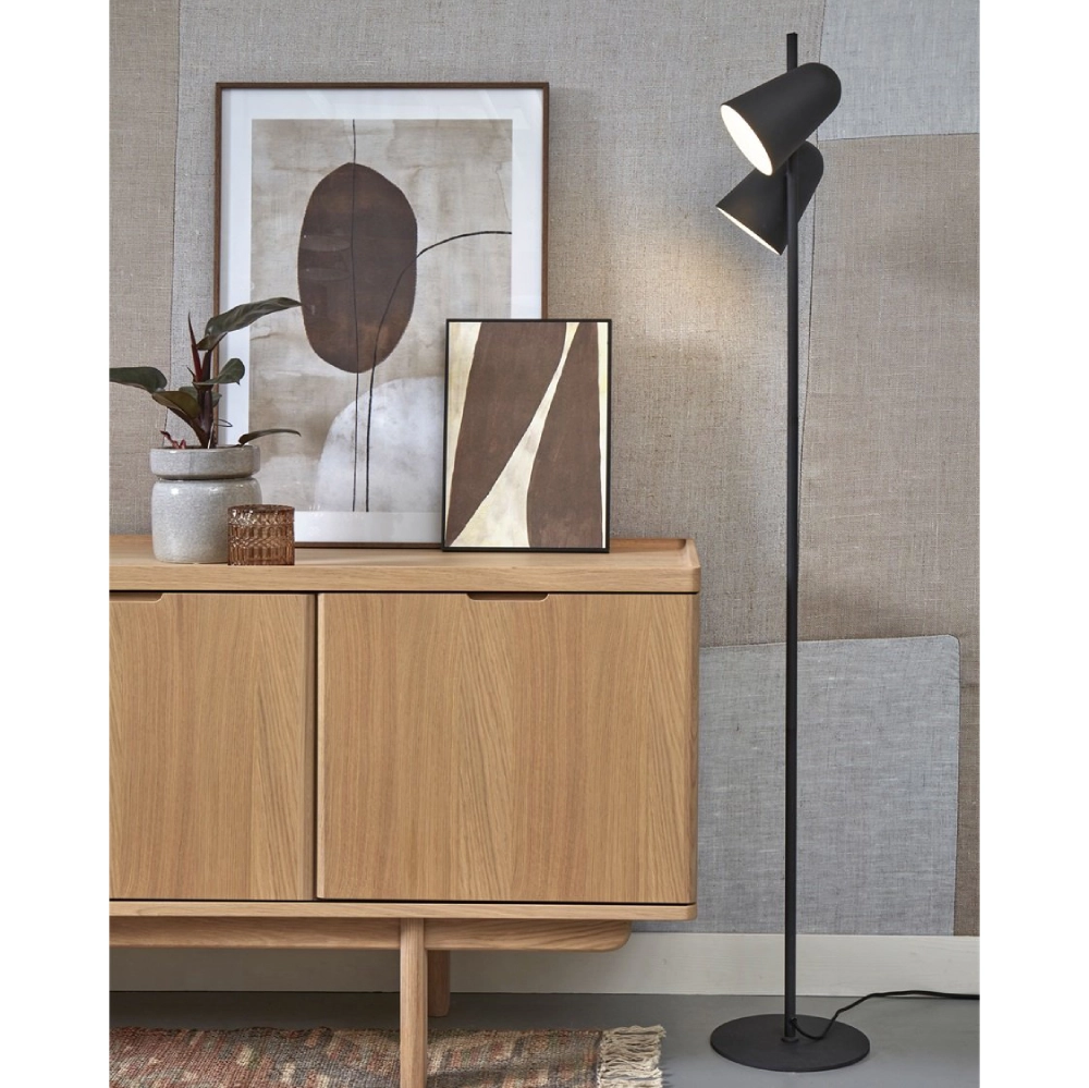 Candeeiro de Pé com Dois Focos Giratórios Salamanca Candeeiro de pé preto com duas lâmpadas ao lado de móvel de madeira e quadros abstratos