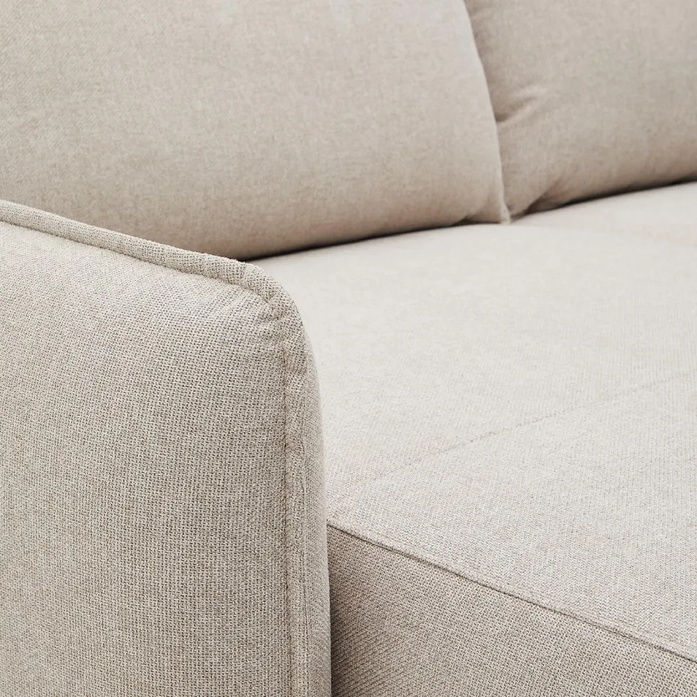 Sofá estofado bege com chaise longue direita/esquerda Karla Sofá de tecido bege claro com textura fina, costura aparente e almofadas acolchoadas