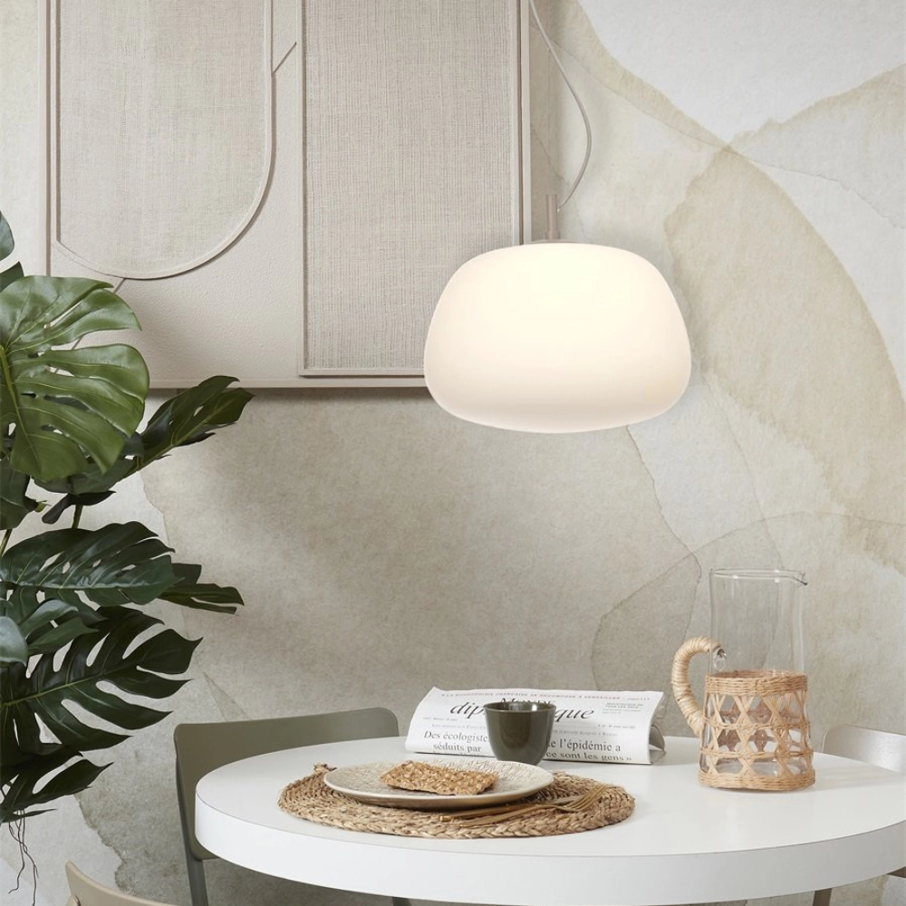 Candeeiro de Teto em Vidro Branco Sapporo Suspensão luminária branca sobre mesa redonda com decoração simples e planta verde ao lado