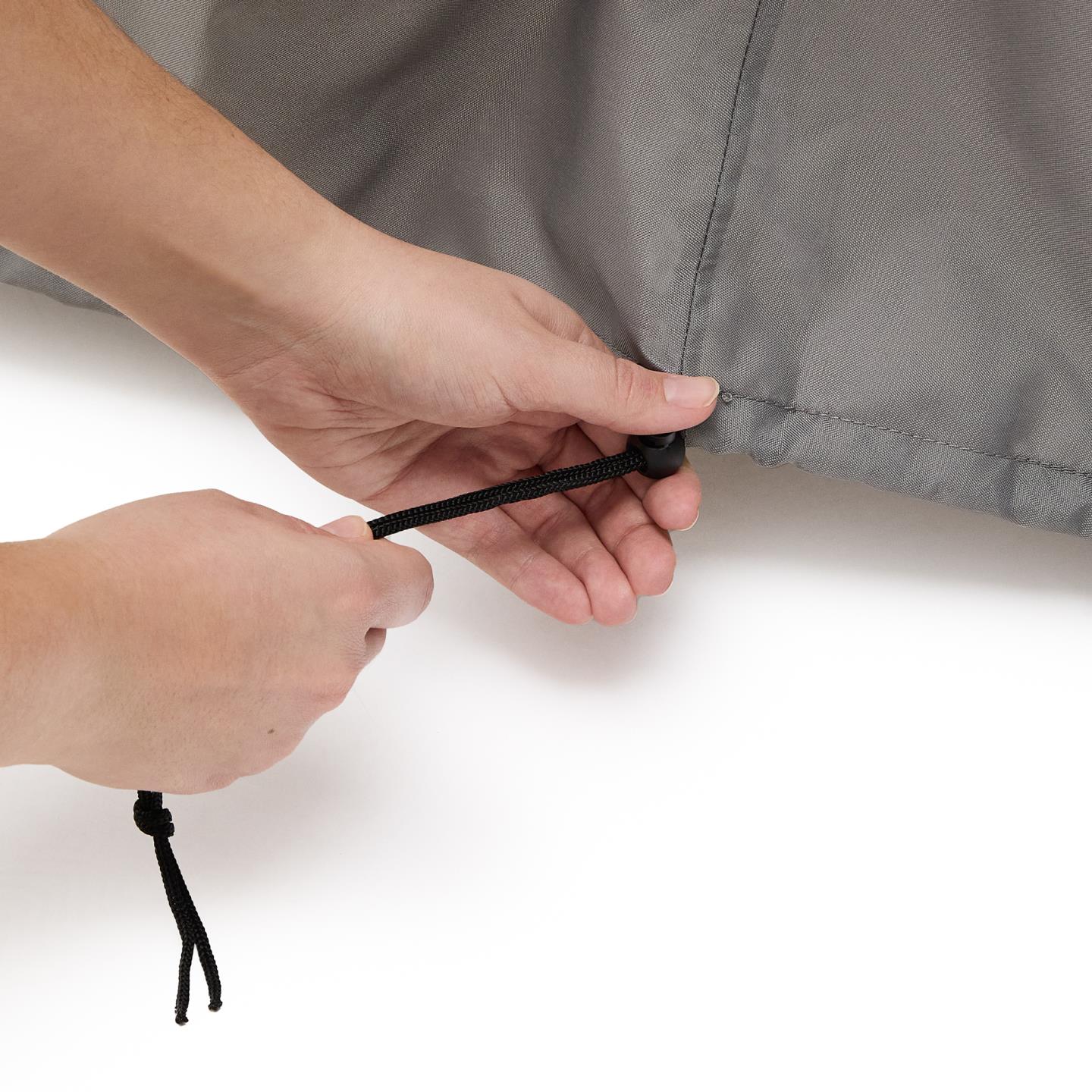 Capa protetora p/mobiliário, exterior Mãos ajustando cordão preto elástico em tecido cinza com trava-corda