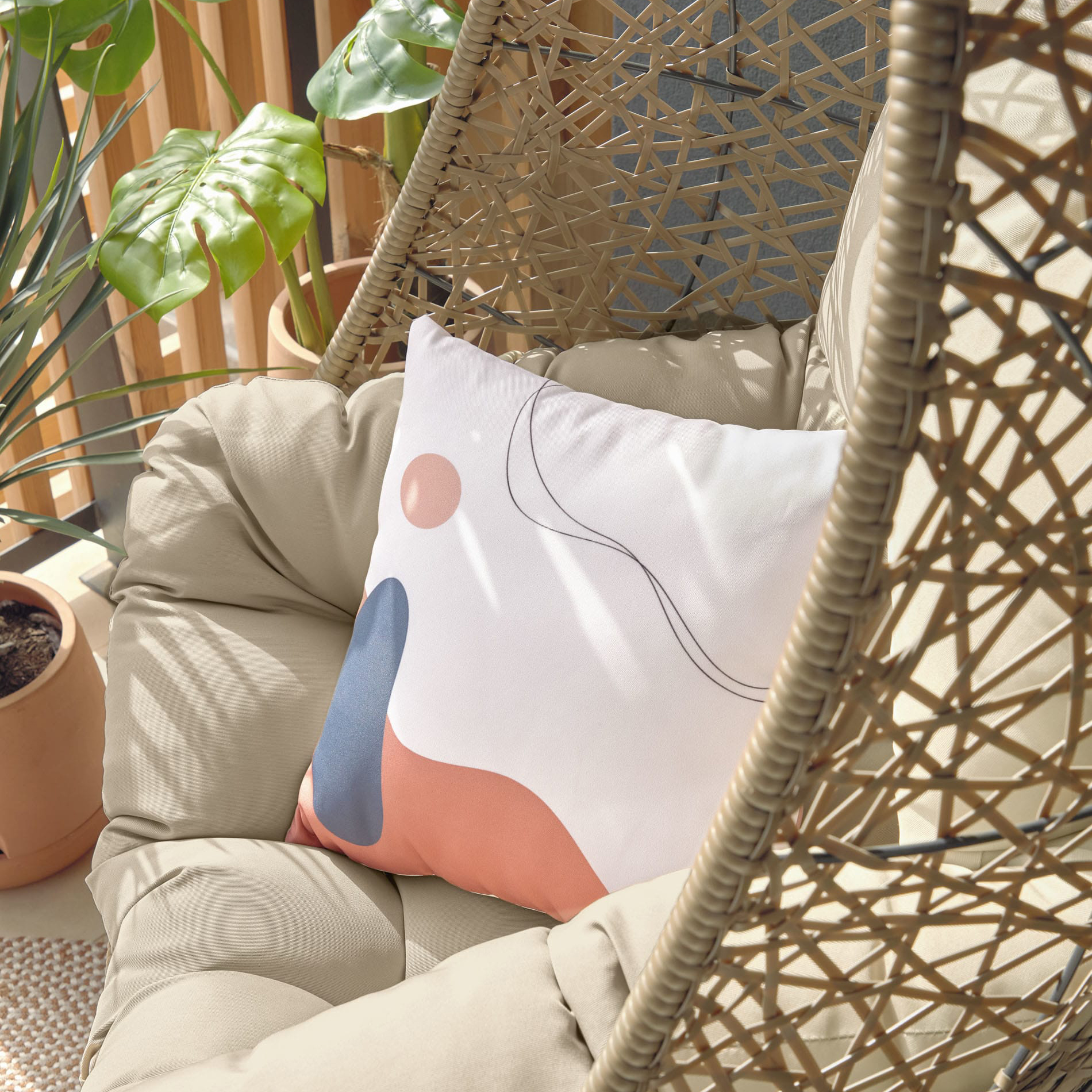 Cadeira suspensa Flora, rattan sintético, castanho Cadeira suspensa em rattan sintético bege com almofadas, planta em vaso e luz natural