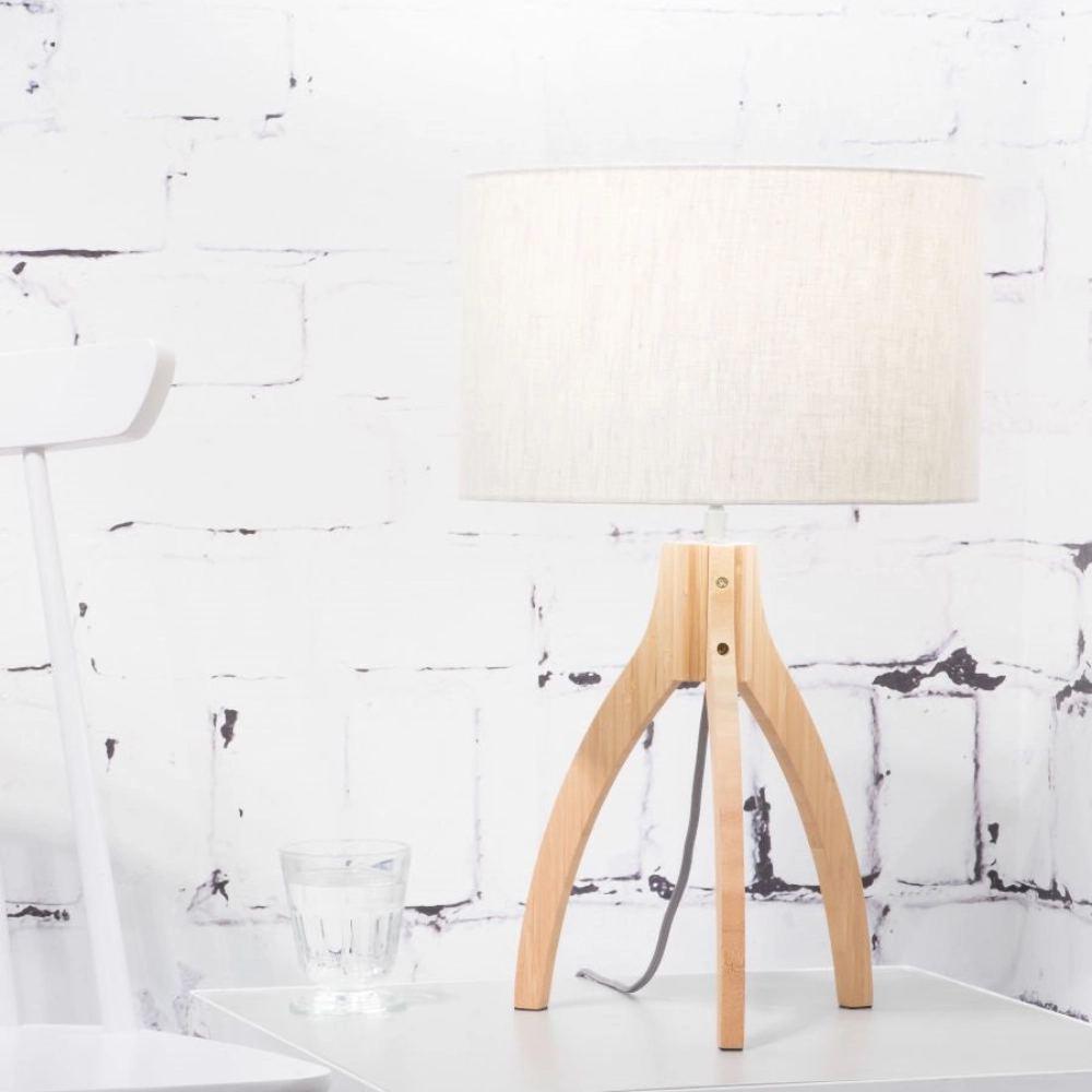 Candeeiro de Mesa em Madeira Bambu e Linho Annapurna Candeeiro de mesa com base em madeira e abaçâo branco numa mesa branca