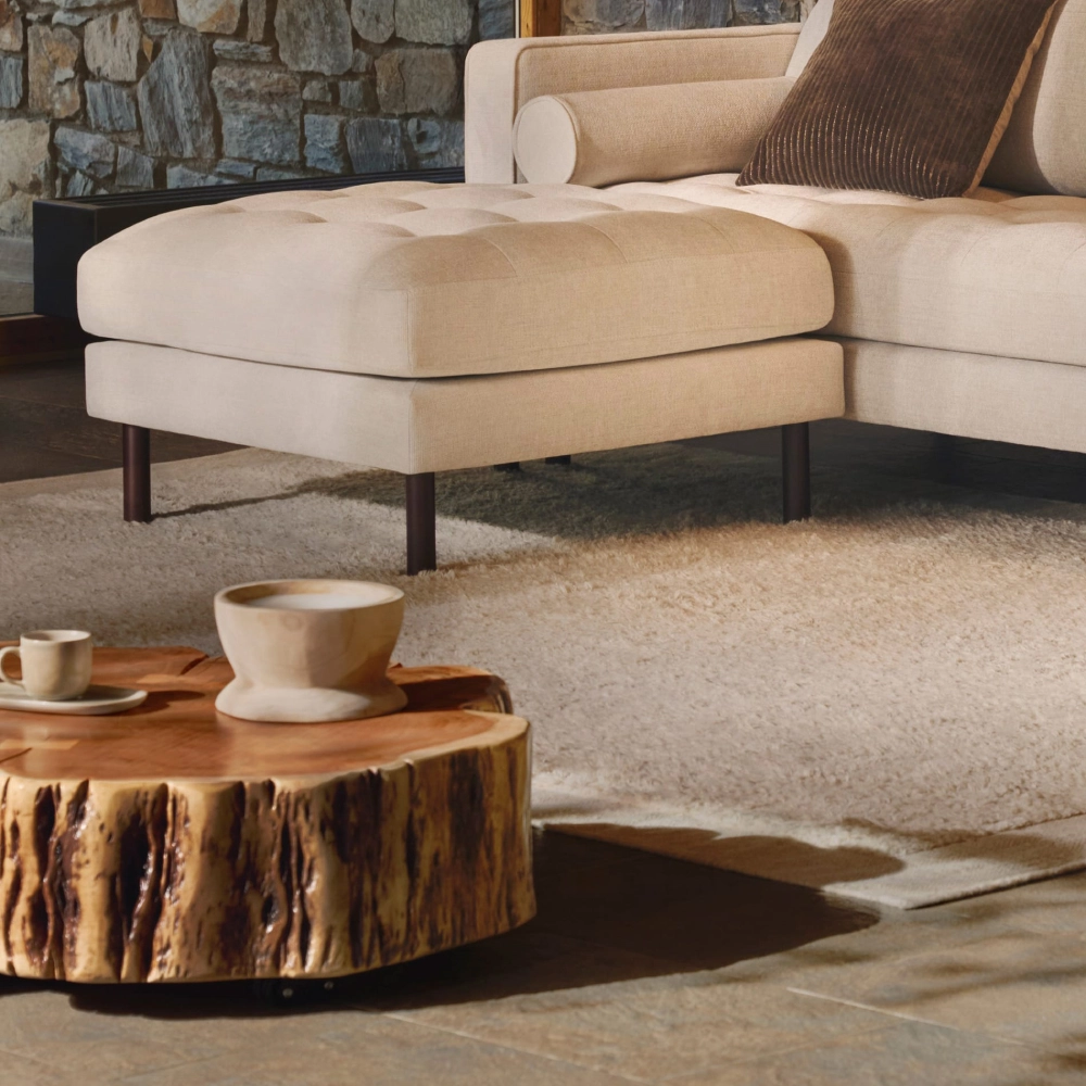 Mesa de centro madeira de acácia com rodas Nuvina Ø65 Pufe estofado beige junto a sofá e mesa de centro de madeira rústica