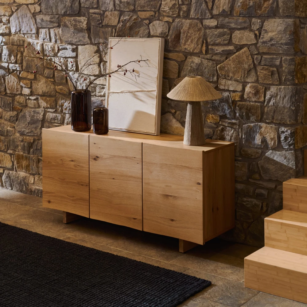 Candeeiro de Mesa em Juta Natural Renne Aparador de madeira clara com decoração e parede de pedra ao fundo