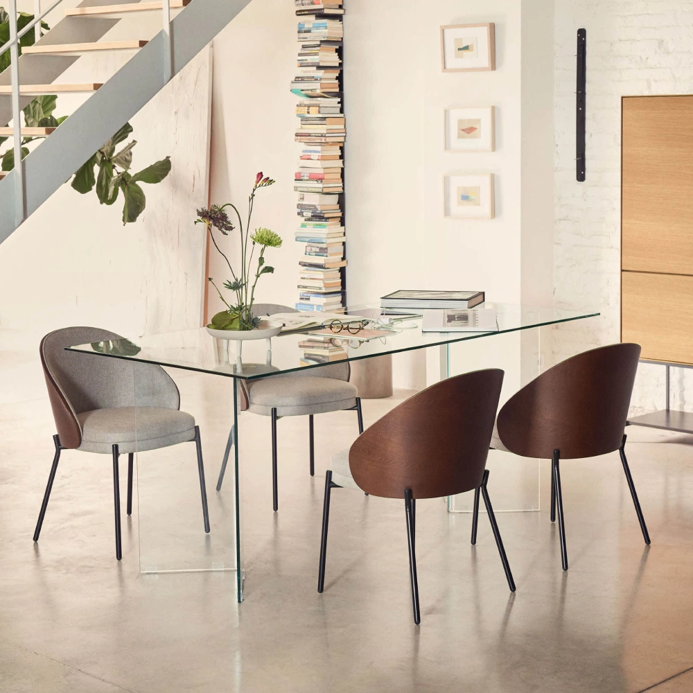 Cadeira estofada chenille em madeira e metal Emmy Mesa de jantar com tampo de vidro e cadeiras modernas castanhas e cinzentas num ambiente contemporâneo