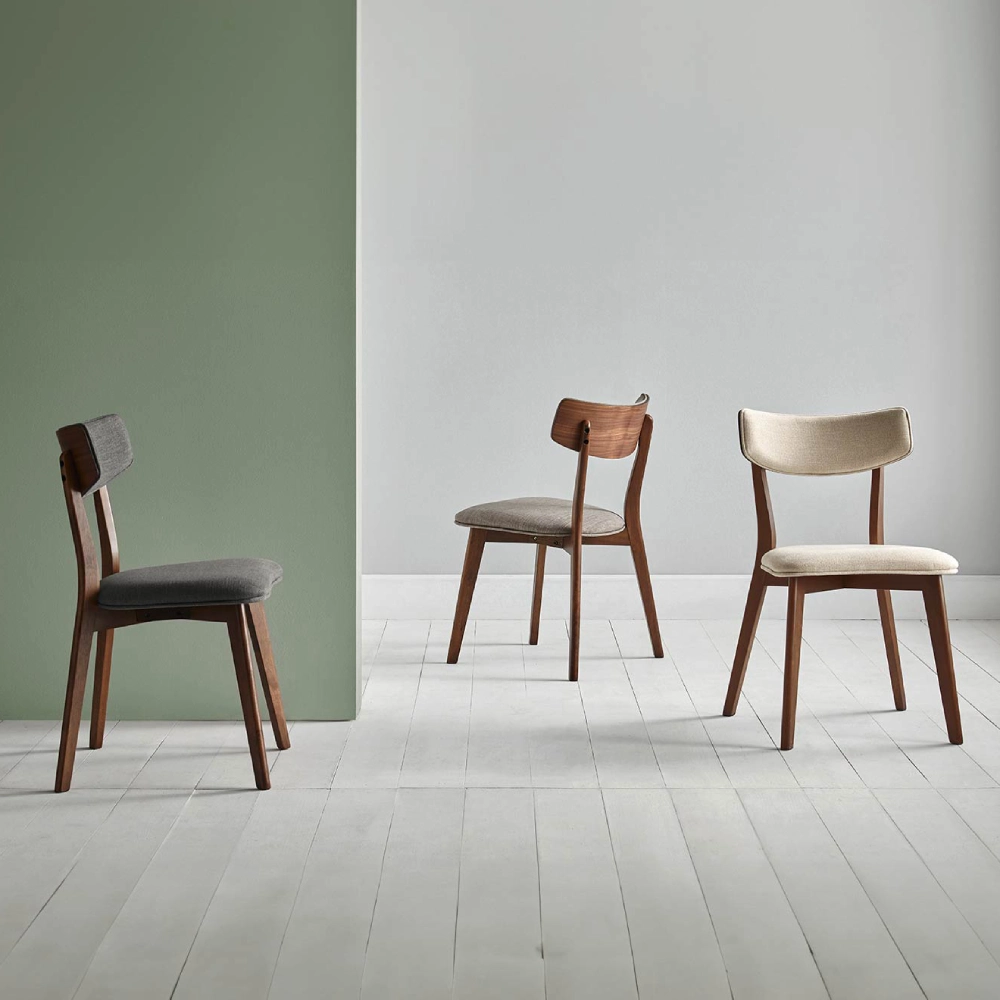 Cadeira estofada bege em nogueira Anais Três cadeiras de madeira com assentos estofados, em ambiente minimalista com parede verde e branca.