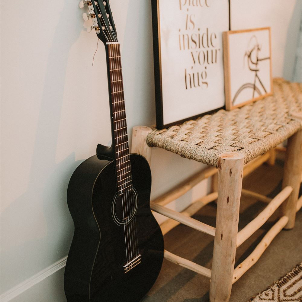 Banco Belgiu, madeira de eucalipto, 136x50 Guitarra preta ao lado de banco de madeira com quadros sobre ele