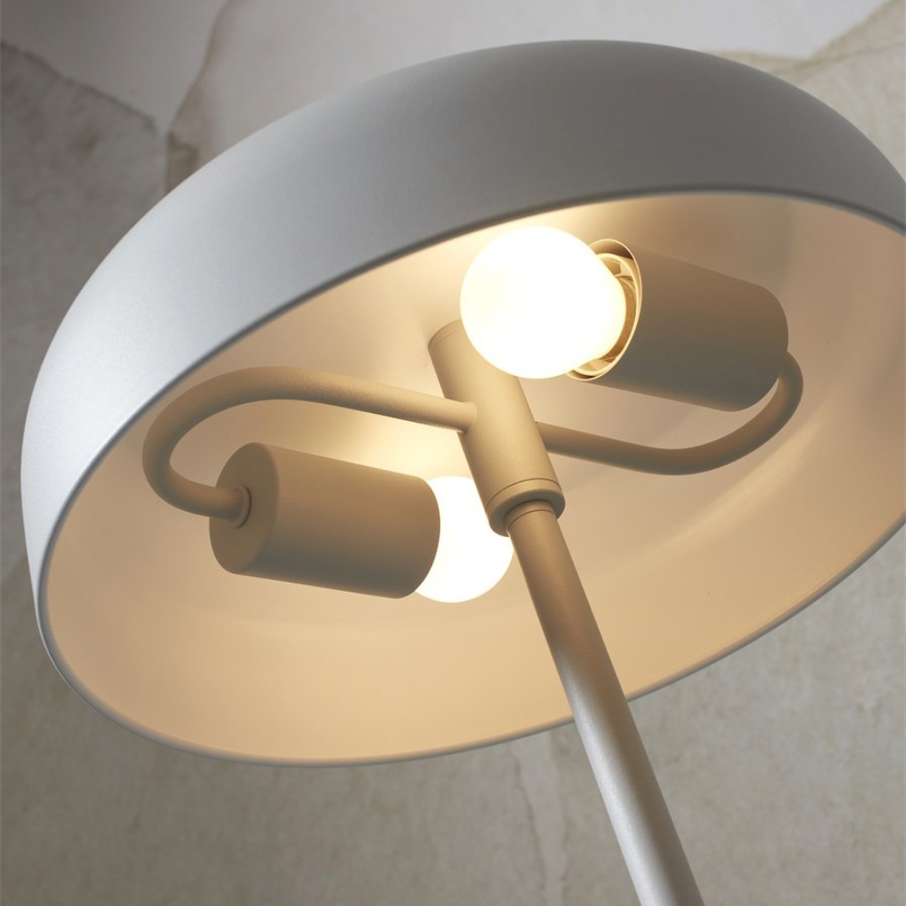 Candeeiro de Pé em Metal Porto Lâmpada de pé branca com duas lâmpadas acesas e fundo de parede bege