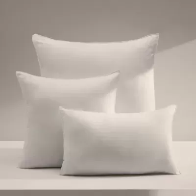 Três almofadas brancas lisas de diferentes tamanhos