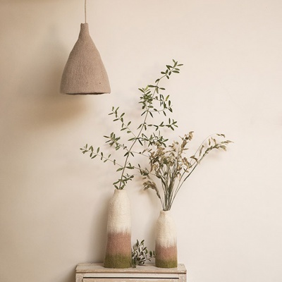 Dois vasos cerâmicos coloridos com ramos secos e verdes, lâmpada pendente de tecido bege