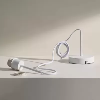 Lâmpada LED branca com suporte e cabo branco sobre superfície clara