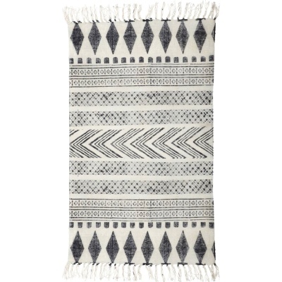 Tapete têxtil preto e branco com padrões geométricos e franjas nas extremidades