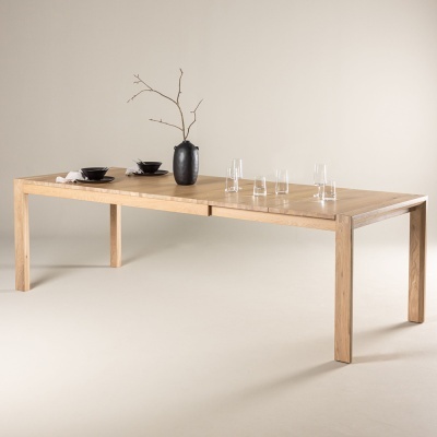 Mesa de jantar retangular em madeira clara com decoração minimalista